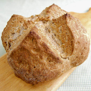 a loaf of irish brown bread on a cutting board.