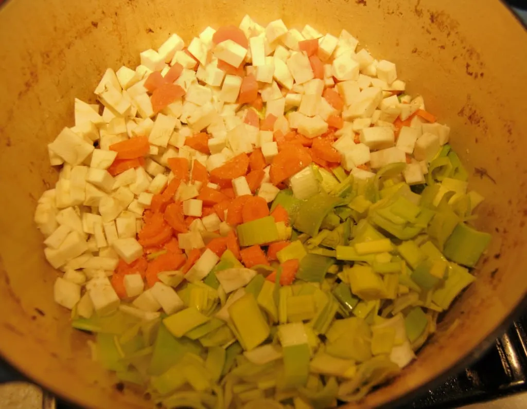 Remove the brown chicken from the pot and add the mirepoix (onion, carrot, celery) and garlic.