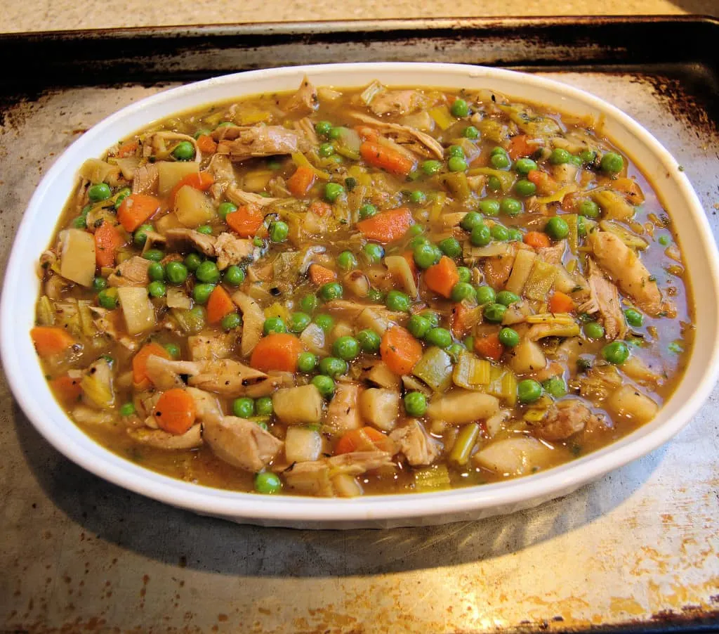 Pour the cooked stew into the baking dish and allow it to cool a little before adding the crust.