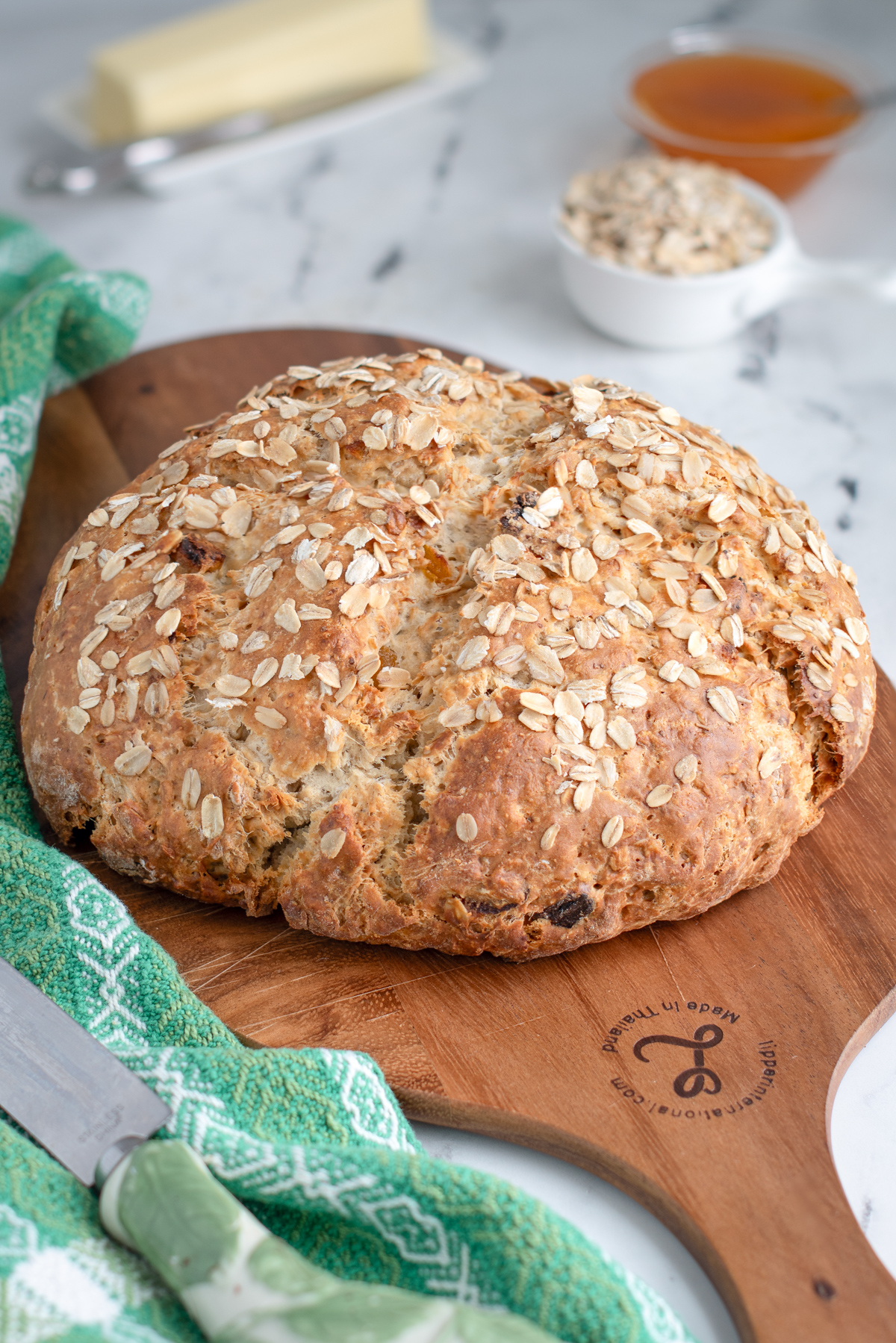 a loaf of oatmeal soda bread on a cutting board. 