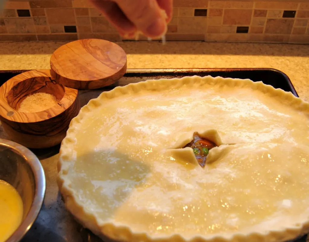 Brush the rim of the dish before placing the crust on top. This will keep the crust from pulling away from the pan.