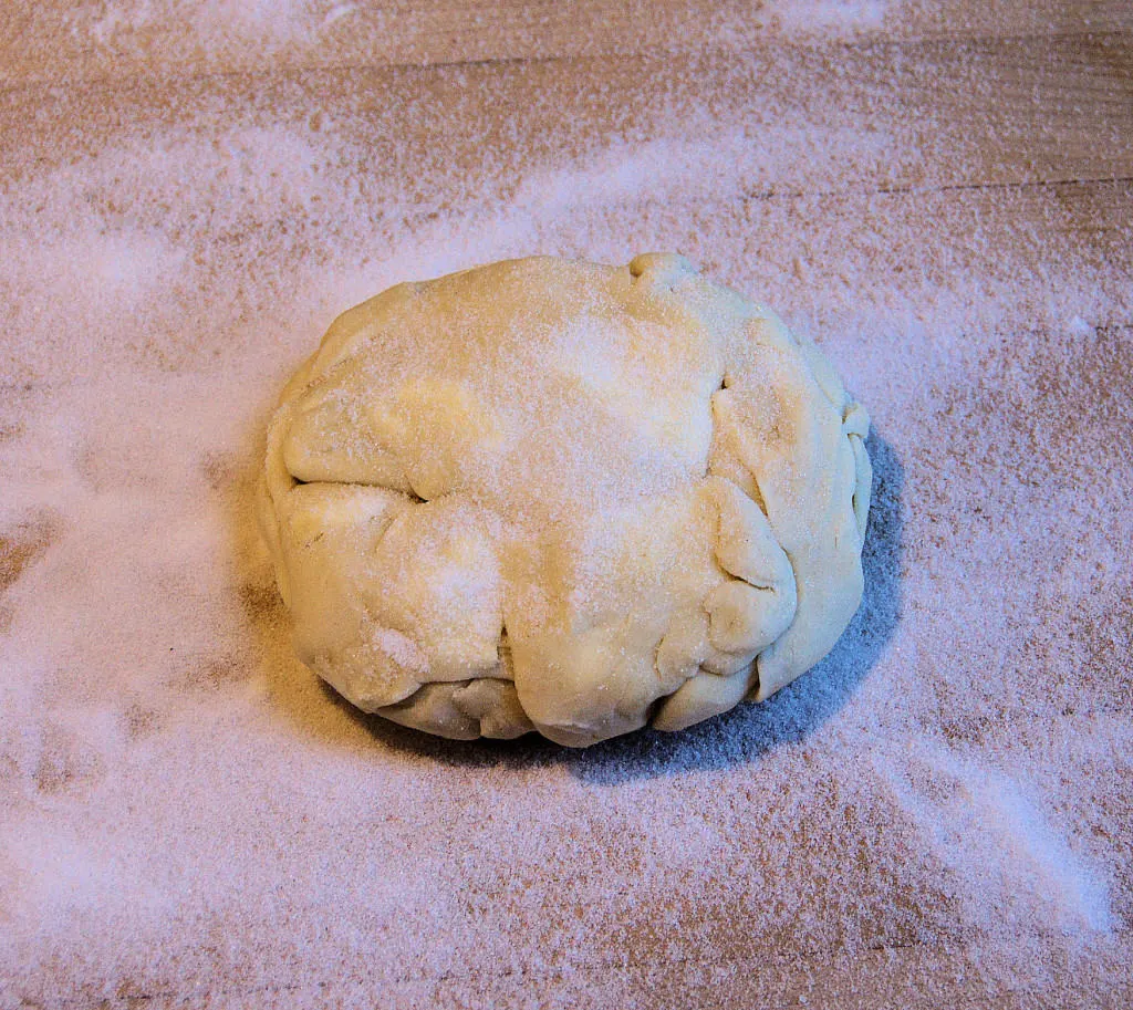 Gather the scraps from rolling the pie dough into a loose ball. The scraps can be refrigerated or frozen to roll later.