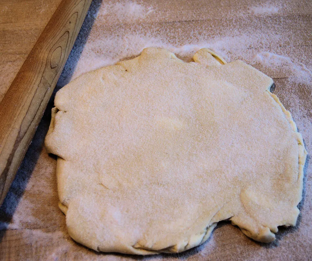 Roll the dough in the sugar, adding more sugar as it's absorbed into the dough.