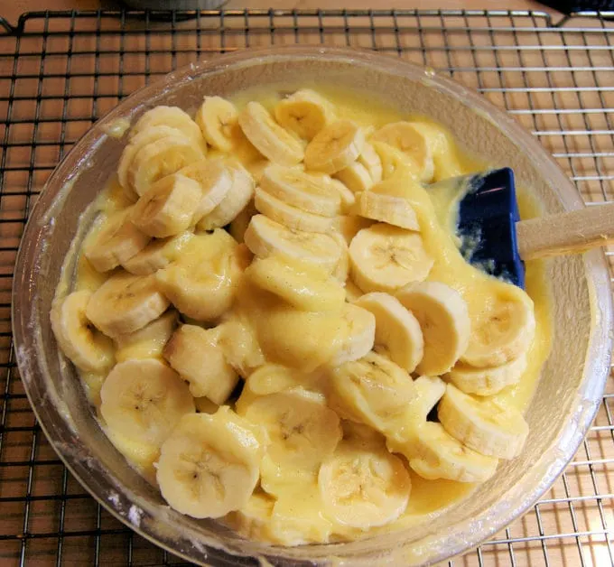 Sliced bananas in a bowl of pastry cream. 