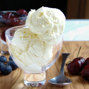 a glass bowl with two scoops of cheesecake ice cream.