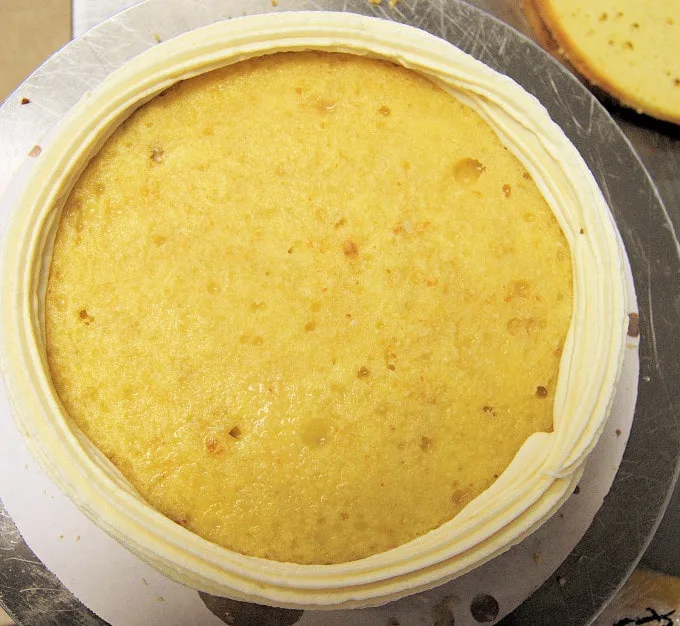 a cake layer with an icing "dam" around the rim