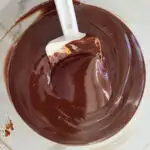 a bowl of chocolate ganache with a spatula