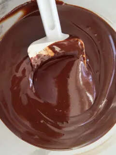 a bowl of chocolate ganache with a spatula