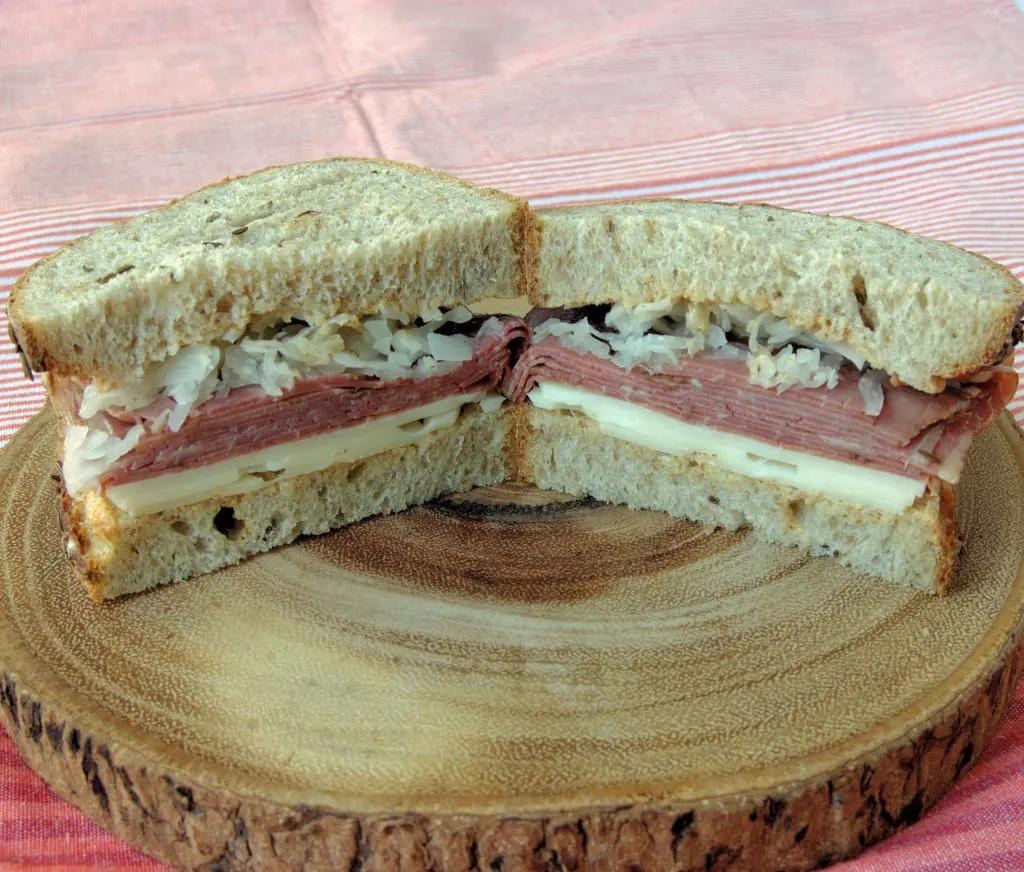 a reuben sandwich on a wooden tray