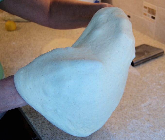 Gently place the dough over your fists and pull the dough to about 12-14"