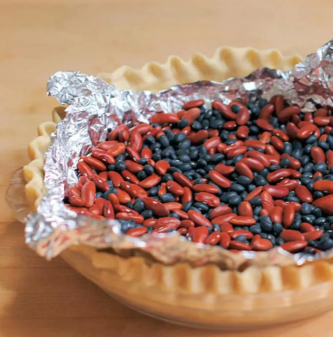 a pie shell lines with foil and filled with dried beans