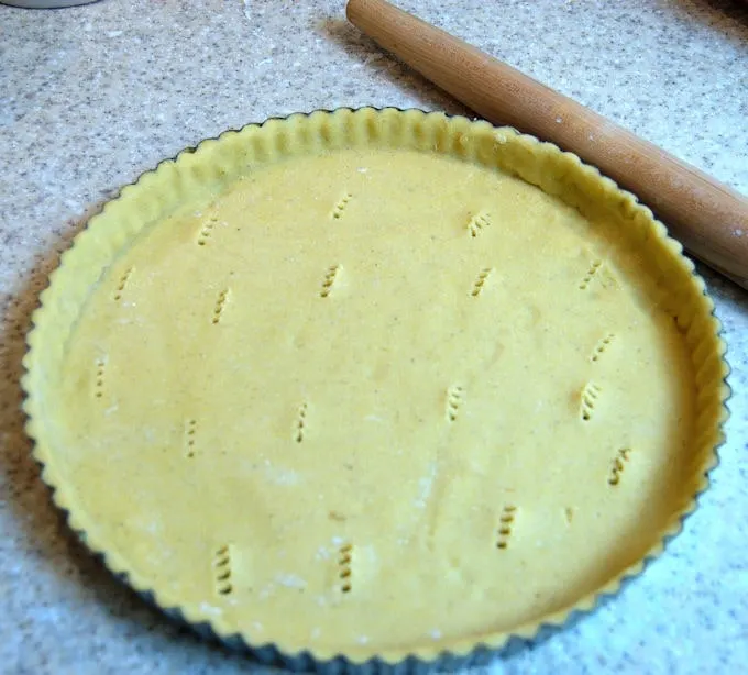 unbaked cornmeal crust in a tart pan