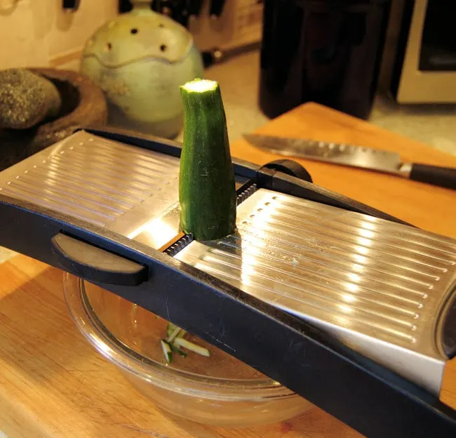 a mandoline slicer with a zucchini on top