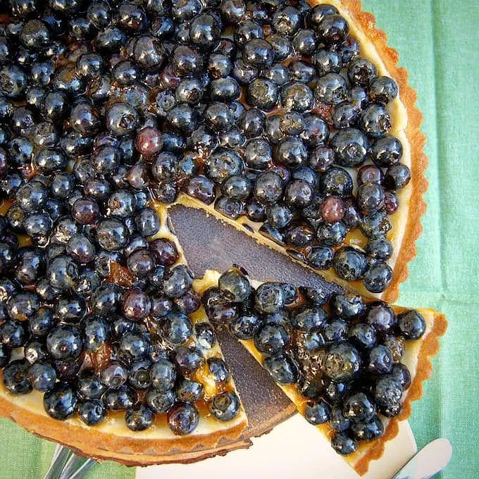 a sliced blueberry cheesecake tart