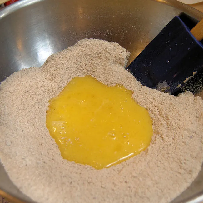 adding wet ingredients to dry ingredients for whole wheat zucchini bread