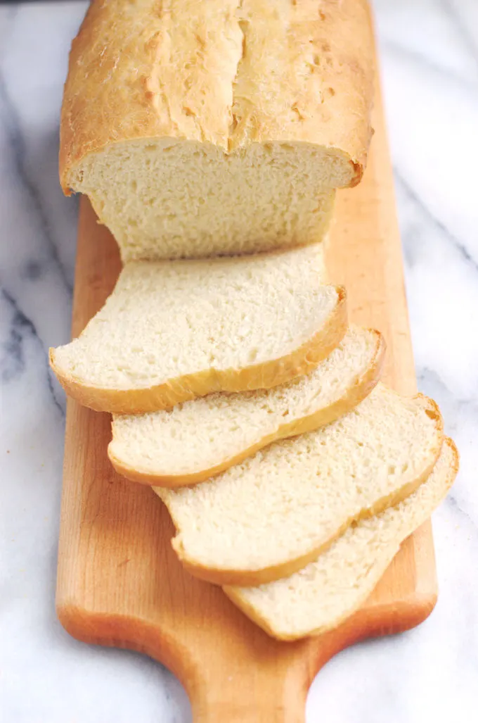 a sliced loaf of white sandwich bread on a cutting board