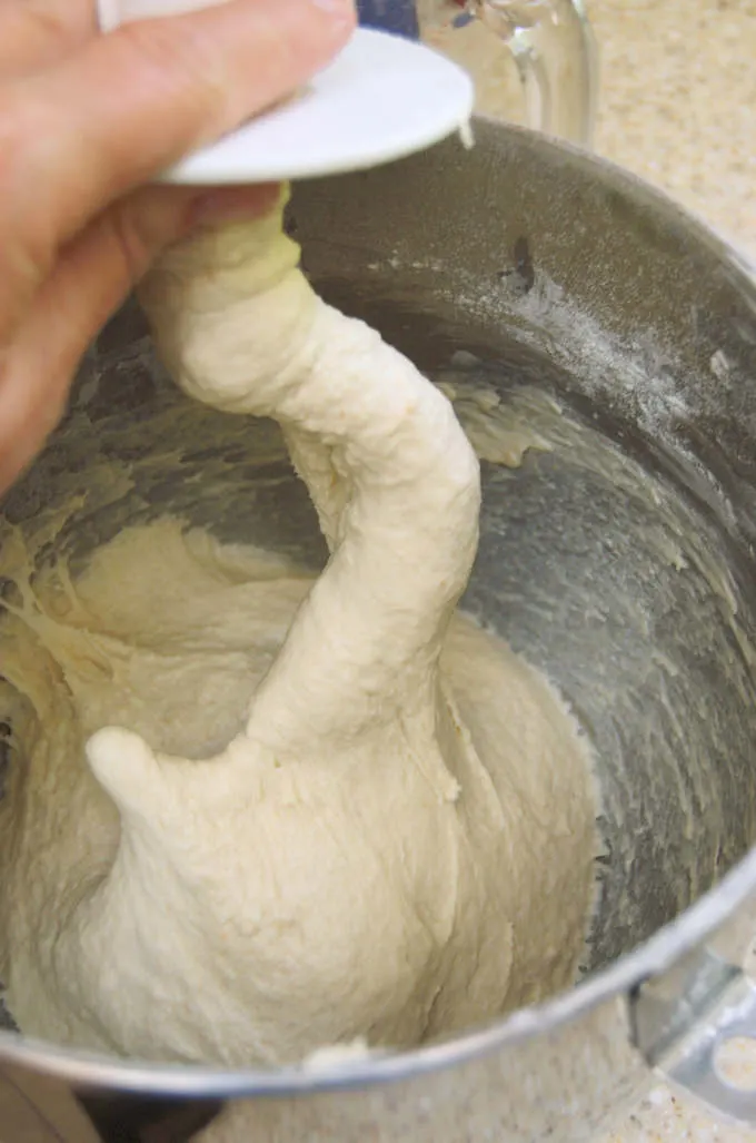 white sandwich bread dough in a bowl with a dough hook