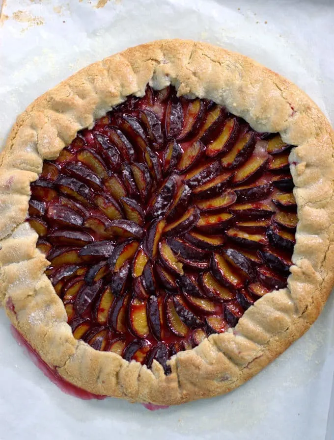 plum galette with a walnut crust on a baking pan
