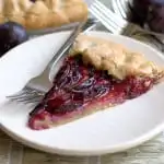 a slice of rustic plum tart with walnut crust