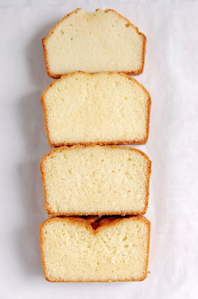 Four slices of pound cake lined up on a white background