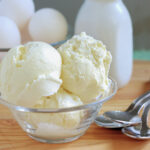 a glass bowl filled with vanilla ice cream.