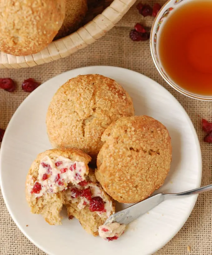 gingerbread scones on a white plate next to a cup of tea.