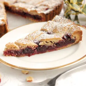 a slice of linzer tart on a white plate.