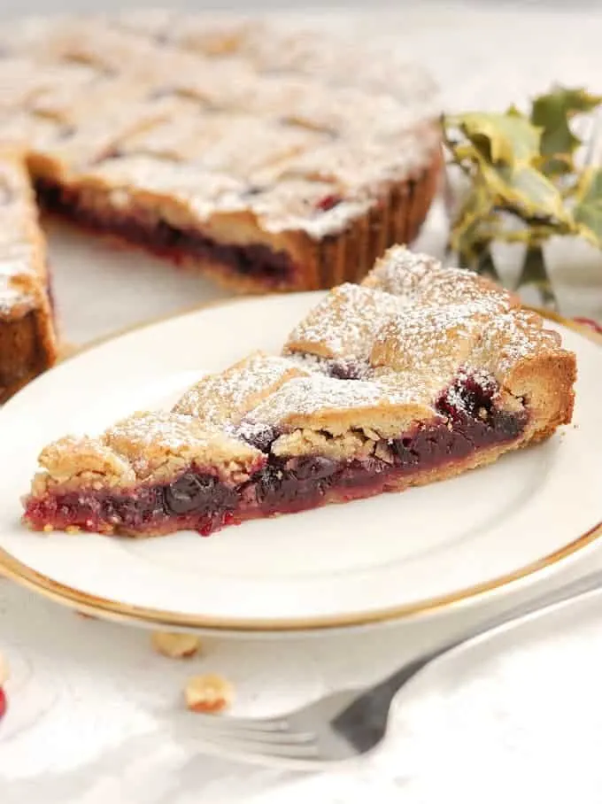 a slice of cranberry linzer tart on a plate