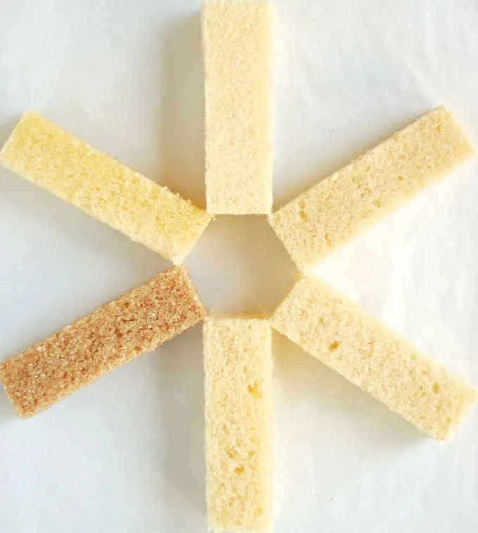 Five pieces of cake arranged in pinwheel pattern on a white surface