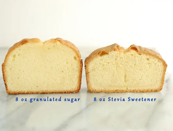 Two pound cake standing on a marble slab. One cake is taller.