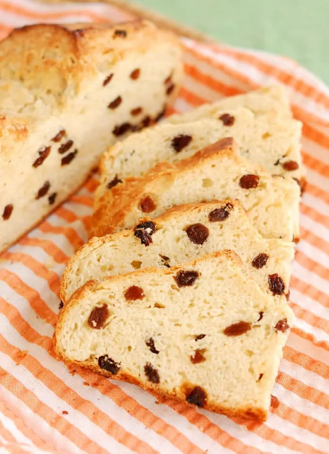 slices of Irish soda bread with raisins on a striped tea towel