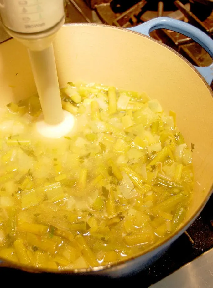 asparagus soup being pureed in a pot.