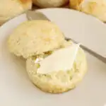 a split biscuit on a plate with butter.