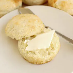 a split biscuit on a plate with butter.