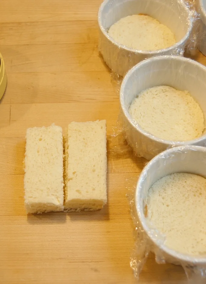 lining the sides of ramekins with bread for summer pudding