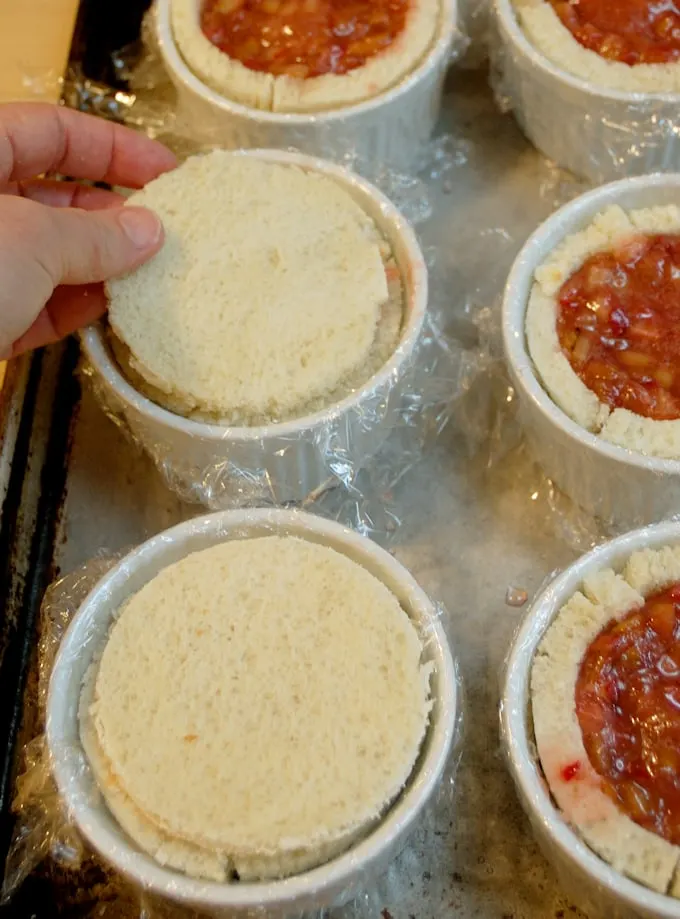 a ramekin with a round of bread covering the rhubarb filling