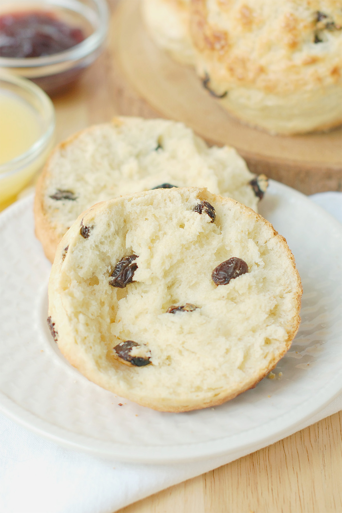 a split raisin scone on a white plate.