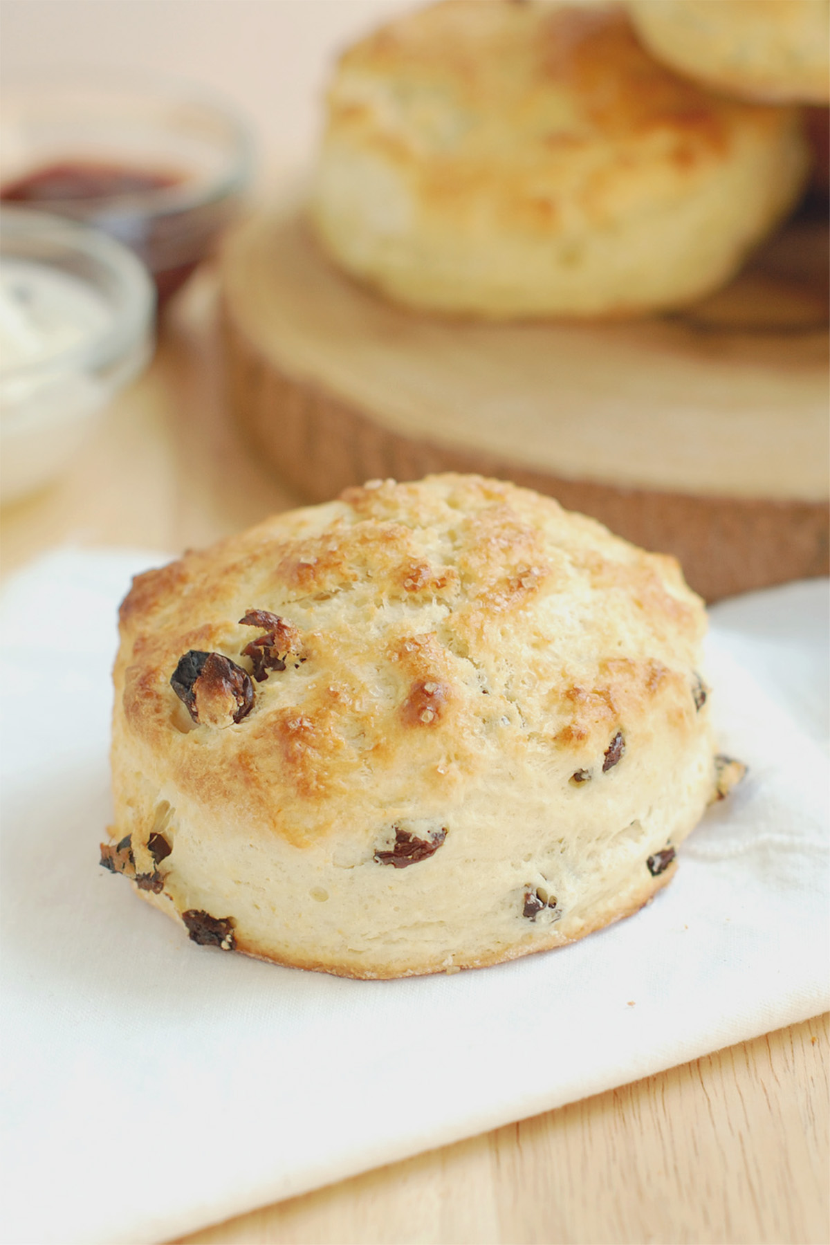 a raisin scone on a table with white napkin.