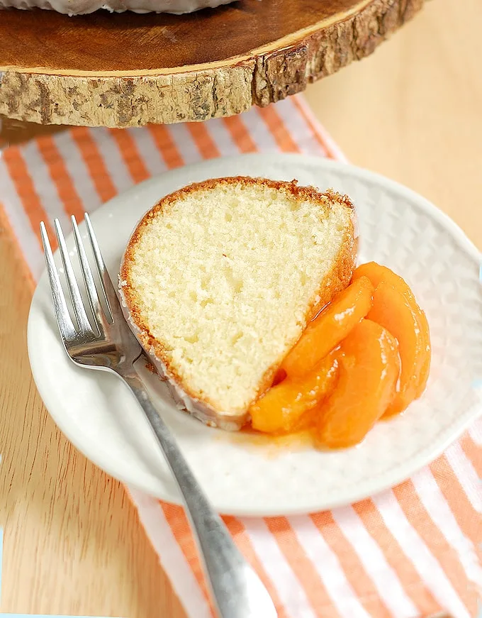 a slice of buttermilk bundt cake on a plate with sliced apricots