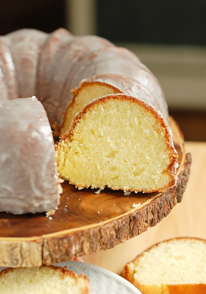 a sliced buttermilk bundt cake on a wood cake stand