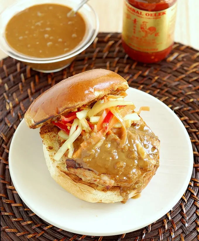 chicken satay burger with peanut sauce on a plate