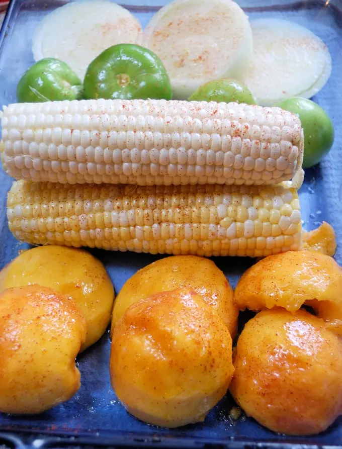 peaches, corn, onions and tomatillos in a baking dish