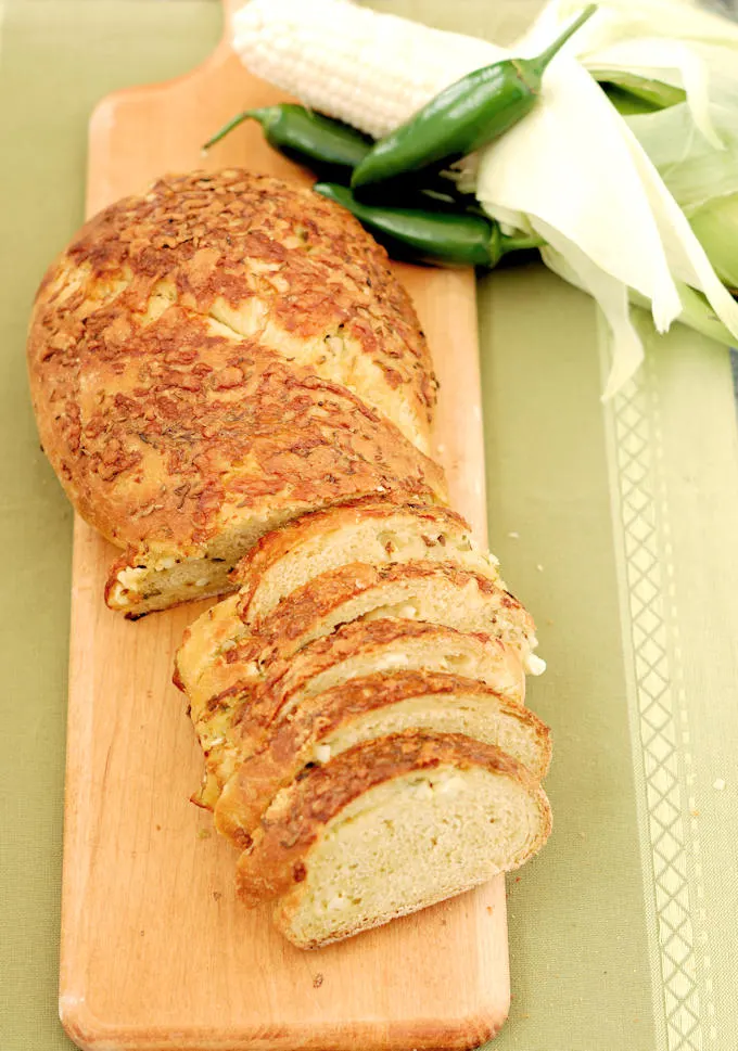 a sliced loaf of sourdough cornbread on a cutting board