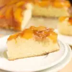 a slice of peach upside down cake on a white plate