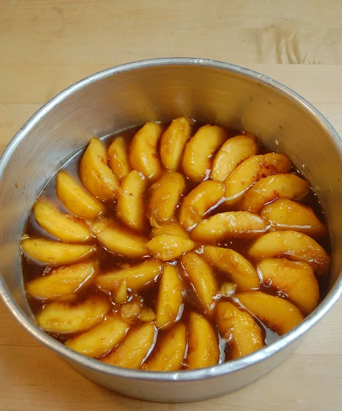 peaches and caramel in a cake pan.