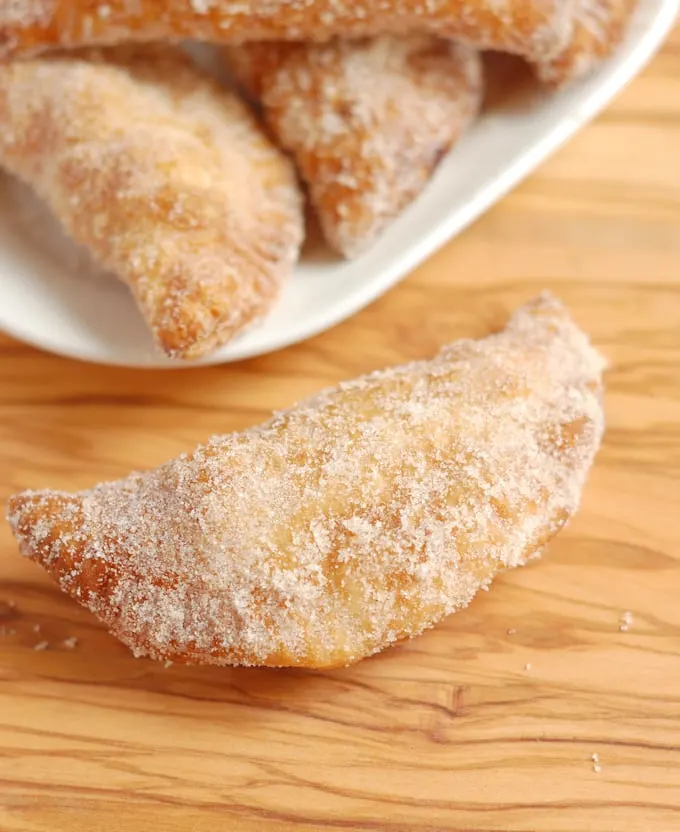 a fried peach pie on a wood surface