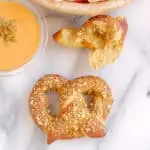 a top view of a pumpkin-spice-ale-pretzel with pumpkin spice dip