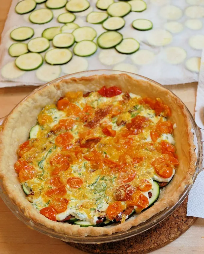 layered ingredients in a pie plate for zucchini pie