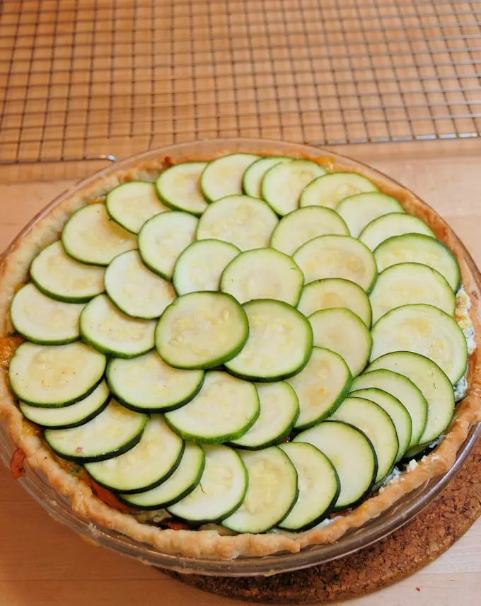 a pie plate with zucchini slices layered in it.
