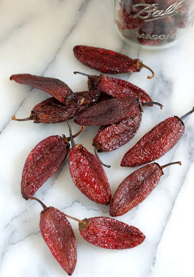 dried chipotle peppers on a marble surface